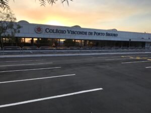 A imagem mostra a fachada do Colégio Visconde de Porto Seguro durante o pôr do sol. Este local foi palco de um projeto educacional realizado pela Mabex Engenharia, que incluiu reformas e reestruturações para otimizar o espaço físico e criar um ambiente moderno, funcional e acolhedor para a comunidade escolar.